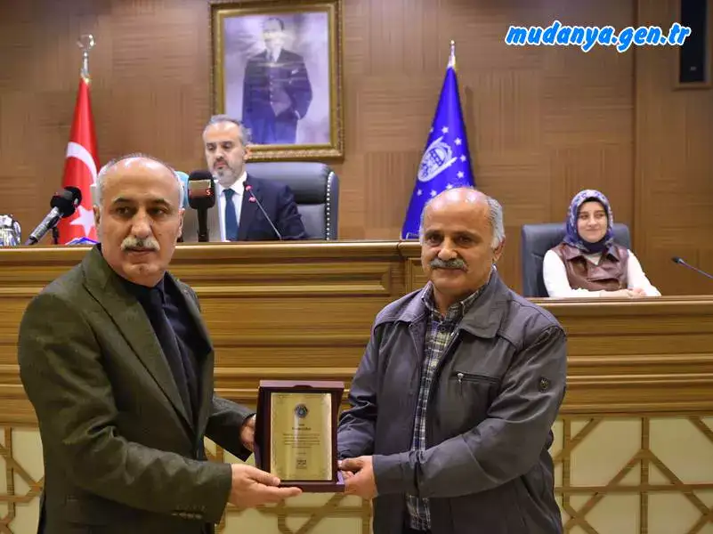 Bursa’da yıllardır topladığı mavi kapaklarla öğrencilere burs ve çeşitli derneklere destek sağlayan ve bu davranışı basına yansıyan Nazmi Gökçe de ayın vatandaşı olarak plaketini Yenişehir Belediye Başkanı Davut Aydın’ın elinden aldı.