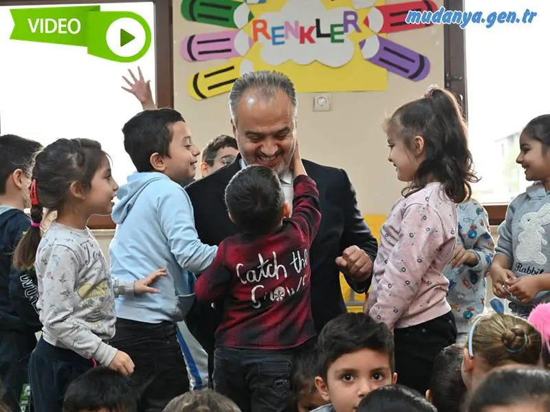 Büyükşehir Belediyesi’nin Ana Kucağı Okul Öncesi Eğitim Merkezlerinde eğitim gören minikler, ‘Şehrim Bursa’ dersinin ‘Başkanımızı Tanıyalım’ konusunu Büyükşehir Belediye Başkanı Alinur Aktaş ile birlikte işledi.  Büyükşehir Belediyesi’nin ‘dar gelirli ailelerin çocuklarının da okul öncesi eğitim hizmetlerinden faydalanabilmesi amacıyla’ 2019 yılında 6 merkezle başlattığı ve bugün adeta dev bir eğitim kurumuna dönüşen Ana Kucaklarında, Milli Eğitim müfredatının yanında ‘Şehrim Bursa’ dersi ile miniklere Bursa’nın değerleri de anlatılıyor. Bu yıl 21 merkezde, 180 öğretmen ve yaklaşık 2 bin öğrenci ile eğitimlerin devam ettiği Ana Kucaklarında, ‘Şehrim Bursa’ dersinin ‘Başkanımızı Tanıyalım’ konusu işlenirken, minik öğrenciler büyük sürprizle karşılaştı. Şirinevler Ana Kucağı’nı ziyaret eden Büyükşehir Belediye Başkanı Alinur Aktaş, hem minik öğrencilere kendini tanıttı hem de onlarla sohbet etti. Oldukça keyifli geçen derste çocuklar, Başkan Aktaş’a Hacivat Karagöz gösterisi sundu, şarkılar söyledi.  Yeni Ana Kucakları geliyor  Ana Kucaklarında miniklerin heyecanını gördükçe kendisinin de çok mutlu olduğunu belirten Başkan Aktaş, ‘Şehrim Bursa’ dersi kapsamında Bursa’nın değerlerinin de çocuklara anlatıldığını söyledi. Zaman zaman yapılan gezi programları ile çocuklara Bursa’yı tanıttıklarını dile getiren Başkan Aktaş, “Çocuklar bizim geleceğimiz. Onların donanımlı bir şekilde hayata hazırlanması tek amacımız. ‘Başkanı tanıyalım’ dersini işlerlerken geldim, hem kendimi tanıttım hem de heyecanlarına ortak oldum. Ana Kucaklarımızın sayısını daha artıracağız. Yeni Ana Kucakları ile daha fazla öğrencimizle bir araya gelmiş olacağız” dedi.